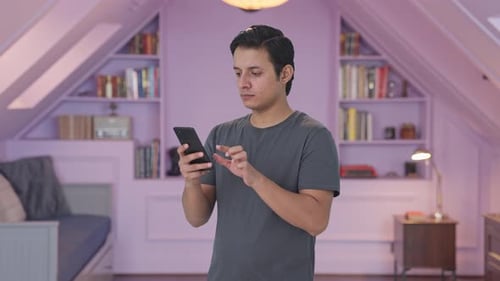 Indian man scrolling through phone