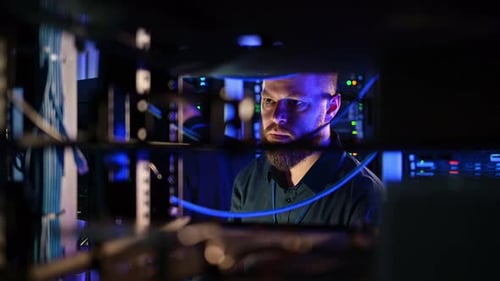 IT Professional Works in Data Center at Night