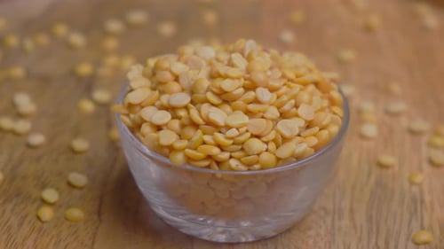 Yellow Split Peas in Glass Bowl on Wood