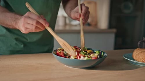 Preparing a Salad with Wooden Utensils at Home