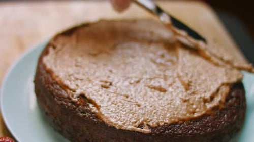 Cake Being Frosted With Chocolate Frosting