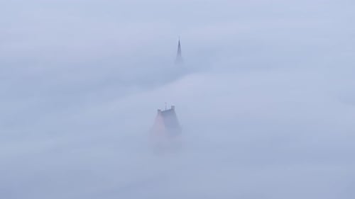 Aerial view of misty morning with church in foggy sunrise, Netherlands.