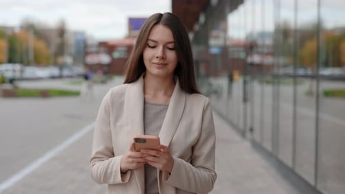 Beautiful Businesswoman Using Modern Smartphone While Walking at Break in the City Professional Lady