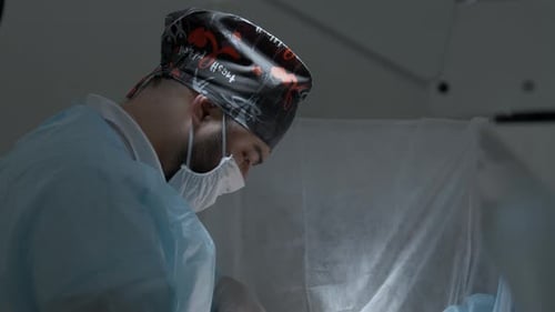 Side view of a surgeon at work in operating room