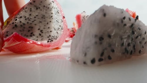 Pitahaya or dragon fruit with white flesh, I pick out the pulp with a spoon. Super close-up.