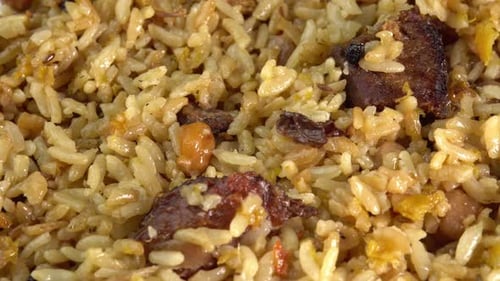 Pilaf macro rotates on a plate. Traditional East Asian dish with chickpeas, barberries, cumin