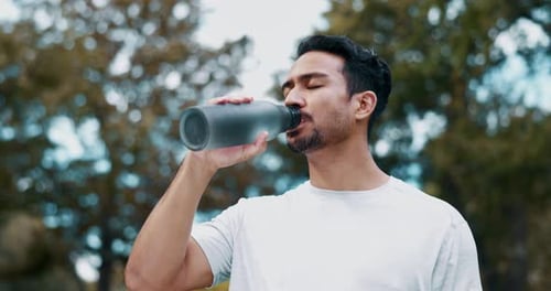 Man Drinks Water From Reusable Bottle Outdoors
