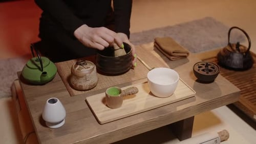 Elegant Hand Preparing Traditional Matcha Tea at Table