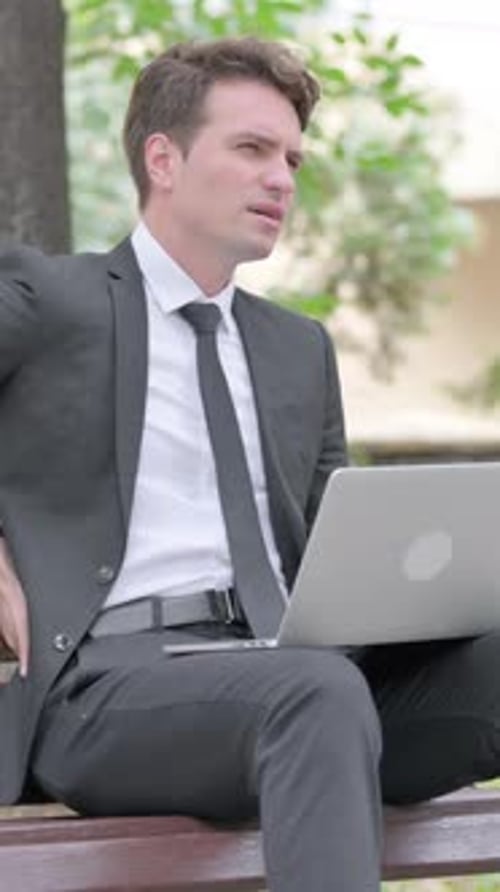 Man Working on Laptop While Sitting Outside