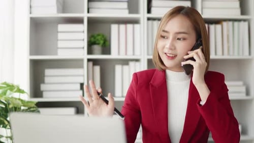 Woman Working at Desk Talking on Cell Phone