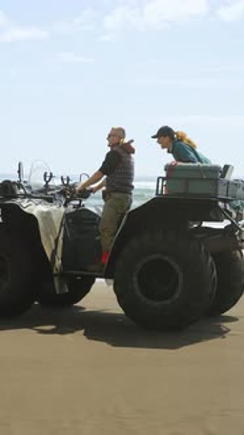 Two Friends Enjoying an Adventure on a Beach in an AllTerrain Vehicle Gathering Experiences and