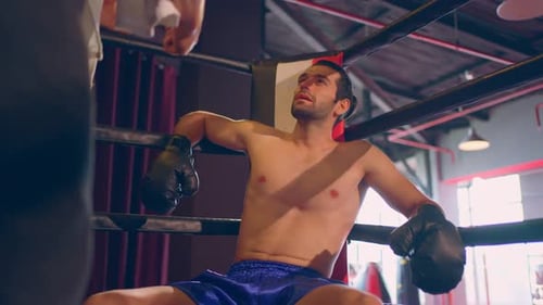 Asian fitness trainer support Caucasian sportsman doing boxing in gym.