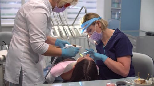 Female Dentist at Work with Assistant