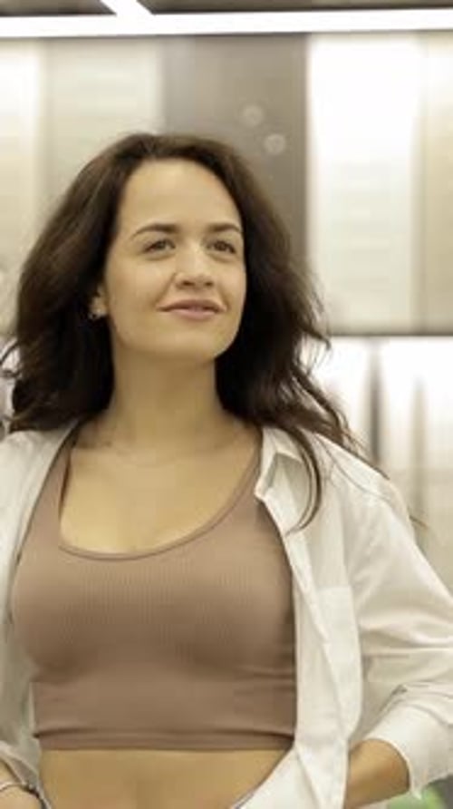 A Young Woman in a Store Chooses Wallpaper for Her Home Vertical Video