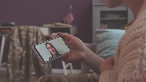 Une militaire discute en vidéo avec sa famille via un smartphone