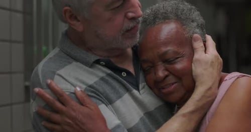 African American elderly woman held close by older man outdoors finding comfort safety and