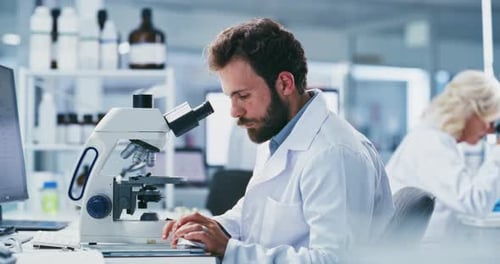 Scientist Using Microscope in Bright Laboratory Setting