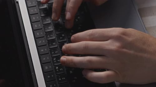 Close Up of Male Hands Typing on Laptop Keyboard with Focused Posture