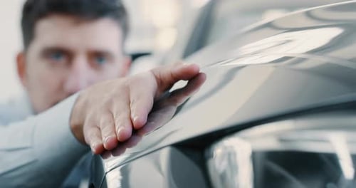 Close up young businessman checking anonymous just repaired in car auto body shop. Slow motion sho