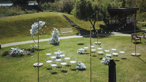 Top View of Wedding Arch Decorations of Flowers in White and Blue Colors with White Chairs and Small