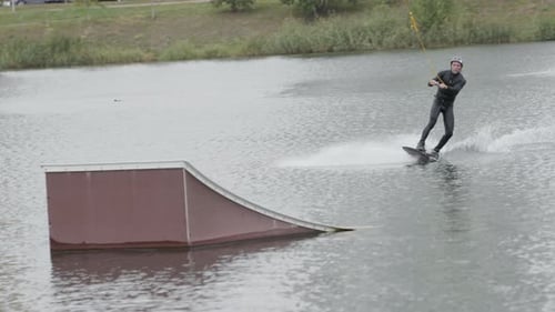 Wakeboard Surfer Making Tricks in Cable Park