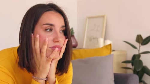 Woman with Hands on Face Thinking Indoors