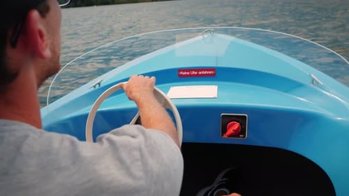 Man Drives Small Blue Boat Across Lake