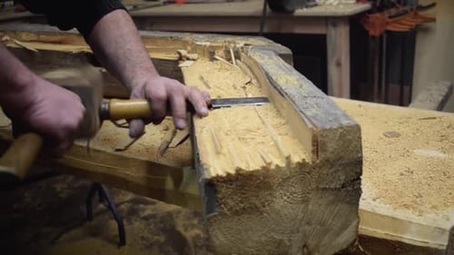 Professional Carpenter Works Piece Of Wood With Wood Hammer And Chisel. Close Up - pan shot.