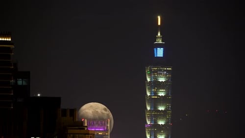 City Lights and the Gleaming Moon: A Nighttime Spectacle.