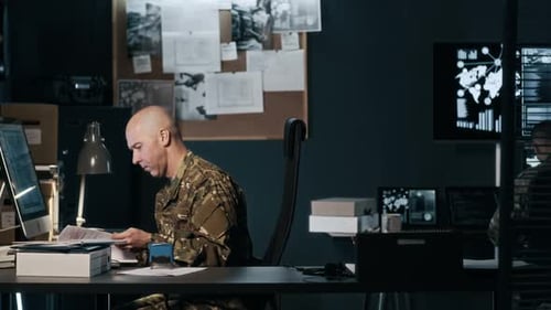 Tired Commander Doing Paperwork Late at Night in Military Hub
