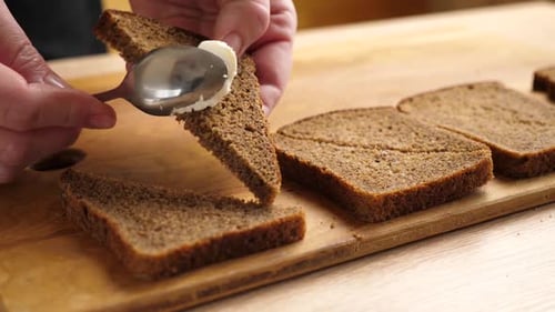 Spreading Cream Cheese on Slice of Brown Bread