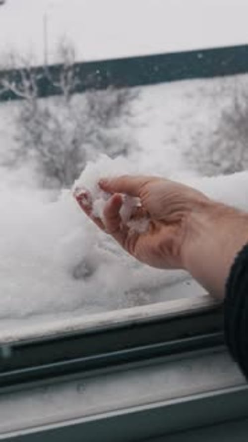 Hand Playing with Snow Near the Window on Winter