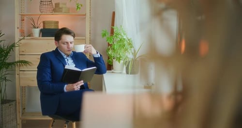 Geschäftsmann liest beim Kaffeetrinken
