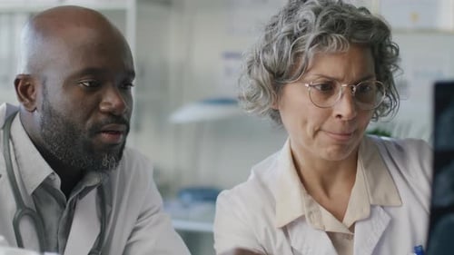 Two Professional Doctors Discussing Brain MRI Scan in Clinic