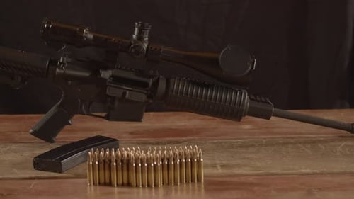 Dolly of AR-15 displayed on wooden surface with ammunition in foreground