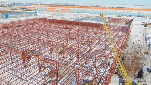 Grúas amarillas cerca de un cadáver rojo en el sitio de construcción de la planta
