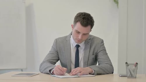 Young Businessman Working on Documents in Office