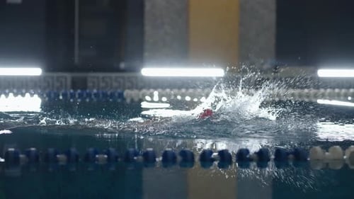 Schwimmerin beim Schwimmen von vorne im Pool, Zeitlupen-Seitenansicht einer Sportlerin