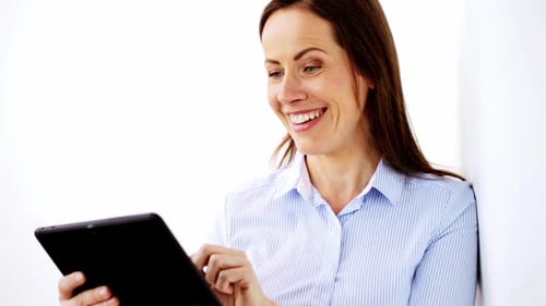 Smiling businesswoman browsing tablet computer in modern office