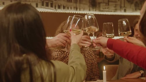 Des amis clignent des verres et boivent du vin dans un café