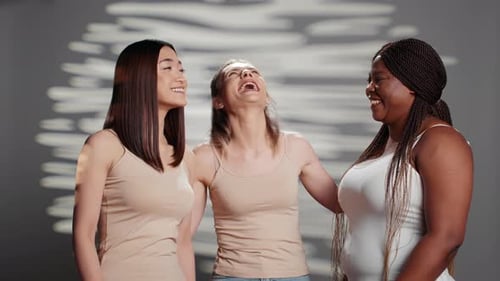 Three Smiling Women Stand Together Laughing