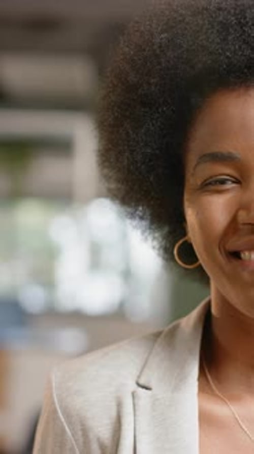 Vertical video of half portrait of african american casual businesswoman in office, slow motion