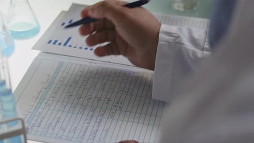 Hands of Scientist Taking Notes on Laboratory Report