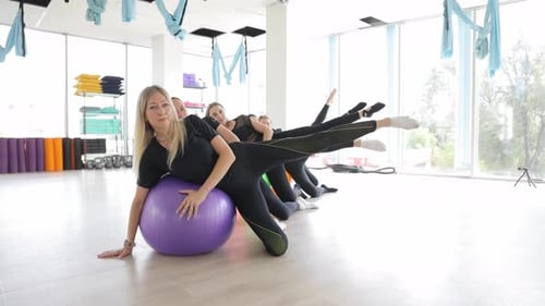 Young Women in a Fitness Center are Training with a Fitness Ball