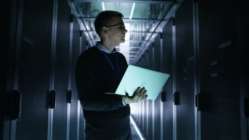 Young Adult with Laptop in a Server Room