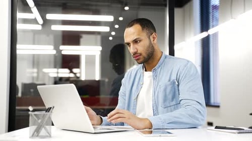 Worried african american businessman having problems with software or service on laptop computer