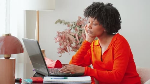 Frustrated Young Woman Experiencing Stress While Studying on Her Laptop in a Cozy Space with a