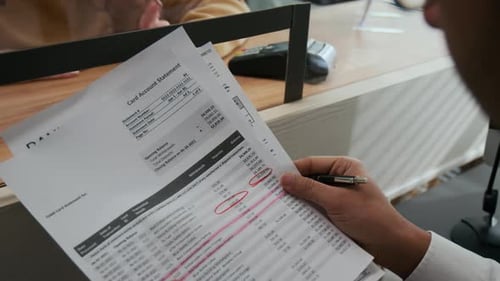 Caixa bancário irreconhecível ajudando cliente confuso na janela de serviço