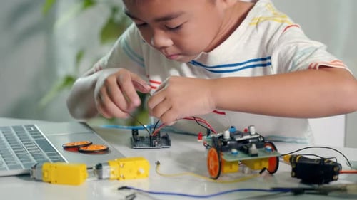 Focused Boy Connects Electronic Circuits at Desk