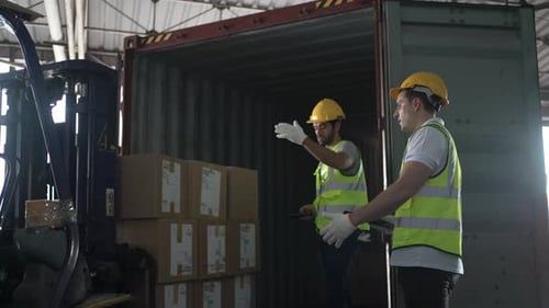 Blue collar workers are working at warehouse.